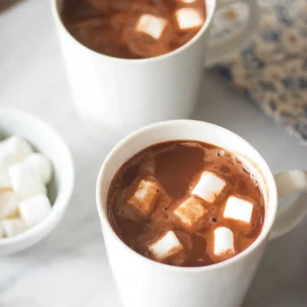 Overhead view of a mug filled with homemade Dairy Free Hot Chocolate topped with mini vegan marshmallows.