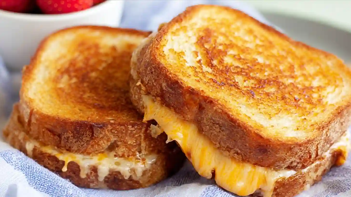 Golden brown Air Fryer Grilled Cheese sandwich cut in half to show melted cheese pull.
