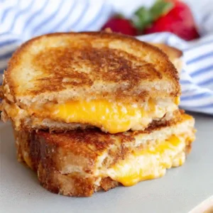 Golden brown Air Fryer Grilled Cheese sandwich cut in half to show melted cheese pull.