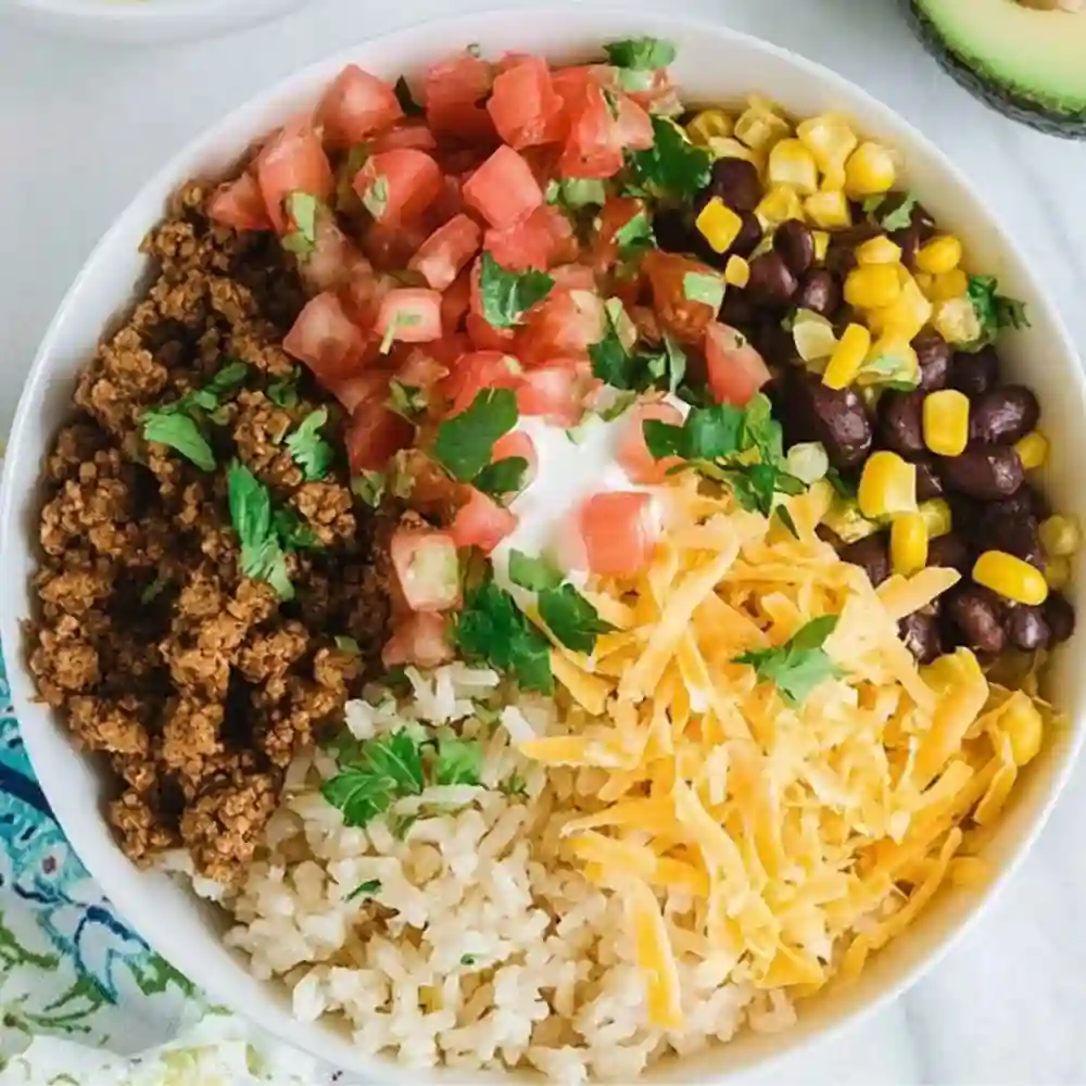 Traditional Okinawan Taco Rice served with shredded lettuce, cheese, and tomatoes.
