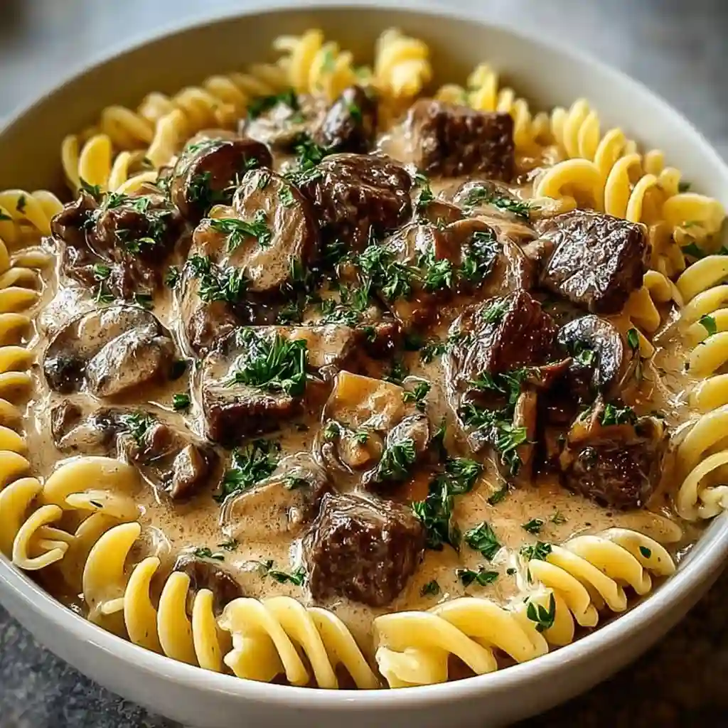  Searing beef strips and mushrooms in a cast iron skillet for stroganoff.